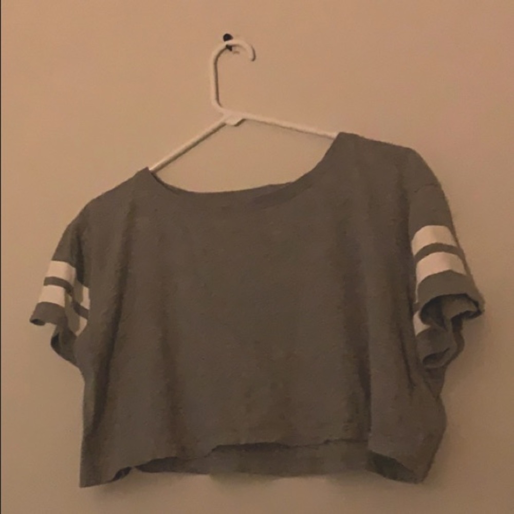 A gray crop top with white lines on the arms sleeves never been worn have no tag